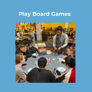 Play Board Games. A Group of people playing board games at a round table in a colorful room.